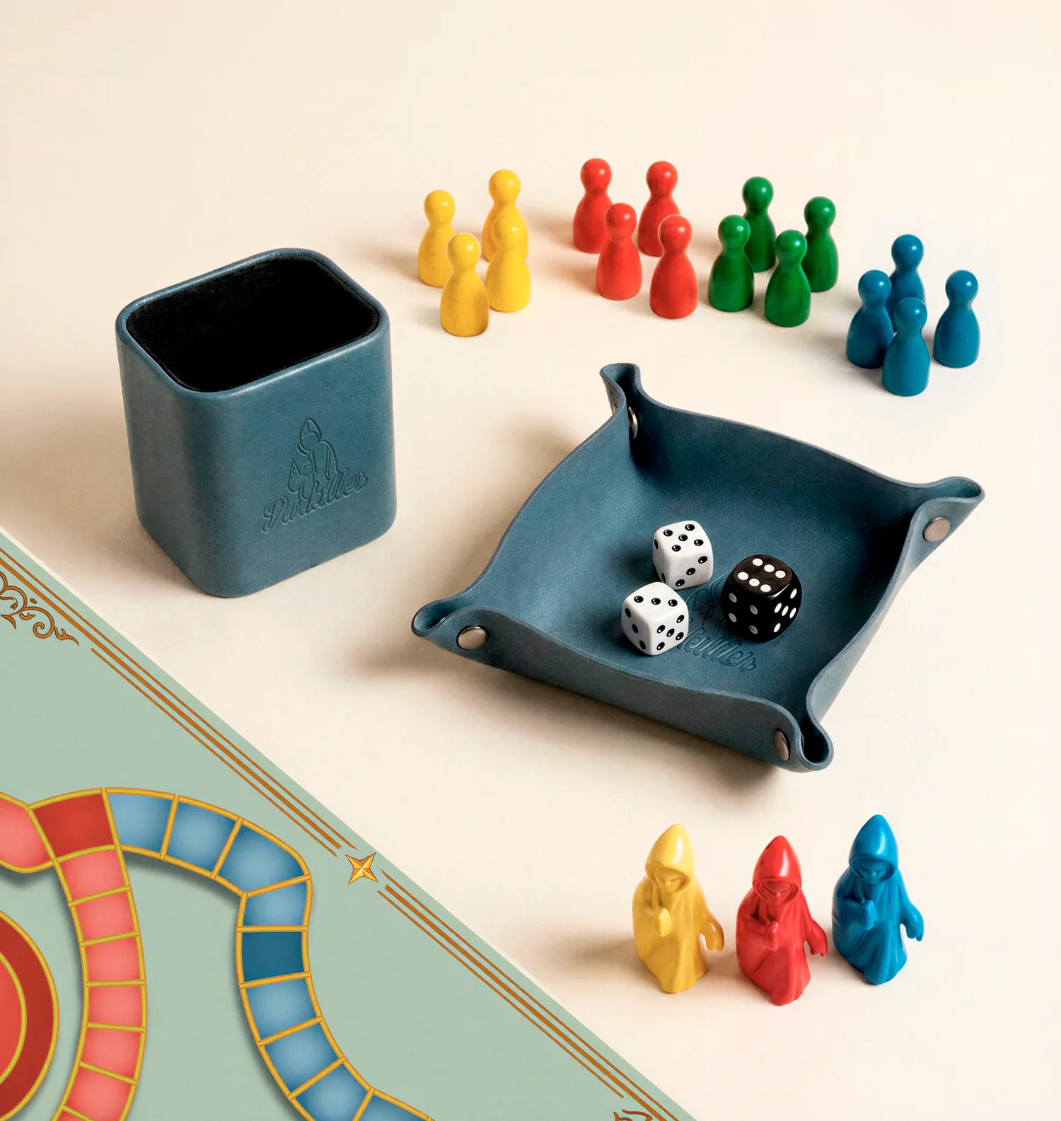 Dice cup, dice tray, wooden pawns and Parki pieces laid out beside the corner of the Parkiller board